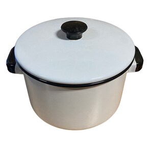 May include: White enamel pot with a black lid and black handles. The pot has a black rim around the top.