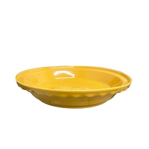 May include: A bright yellow pie dish with a scalloped edge. The ceramic dish has a smooth, glossy finish and a shallow, round shape. The dish is designed for baking and serving pies.