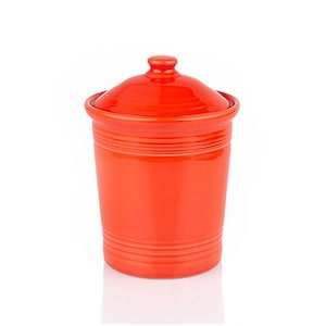 May include: A vibrant red ceramic canister with a matching lid. The canister has a cylindrical shape with horizontal ridged detailing around the body. The lid features a small knob for easy removal. This kitchenware item is suitable for storing dry goods.