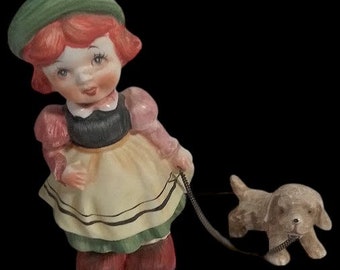 Figura de porcelana vintage de una niña holandesa con un perro