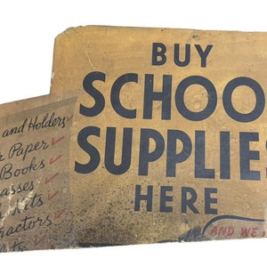 Letrero de cartón con anuncio antiguo de material escolar