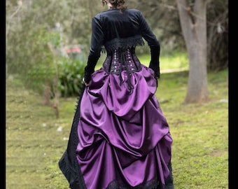 May include: A floor-length dress featuring a deep purple satin skirt with black lace trim at the hem, paired with a black long-sleeved bolero jacket and a black corset bodice with lace-up back detailing, viewed from the back.