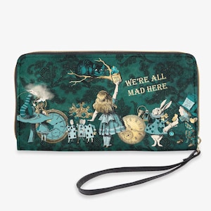 May include: A green zippered wallet with a whimsical Alice in Wonderland theme. The wallet features a green and gold patterned background with images of Alice, the Mad Hatter, the White Rabbit, and the Cheshire Cat. The text "We're All Mad Here" is printed in gold on the front of the wallet.