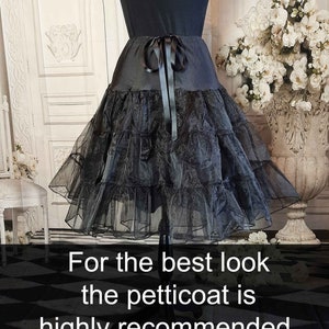May include: A black petticoat featuring a smooth waistband with a tied ribbon bow at the center front and multiple layers of sheer, ruffled tulle fabric. The image includes the text: For the best look the petticoat is highly recommended.