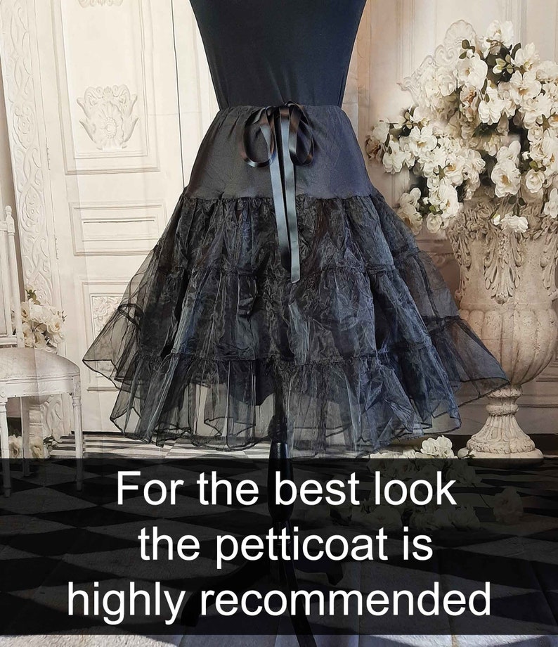 May include: A black petticoat featuring a smooth waistband with a tied ribbon bow at the center front and multiple layers of sheer, ruffled tulle fabric. The image includes the text: For the best look the petticoat is highly recommended.