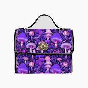 Peut inclure: Sac à main avec une poignée noire et un motif de champignons violets. Le sac est orné d'un fermoir doré et de bordures noires. Le motif présente des champignons violets et du feuillage sur fond sombre.
