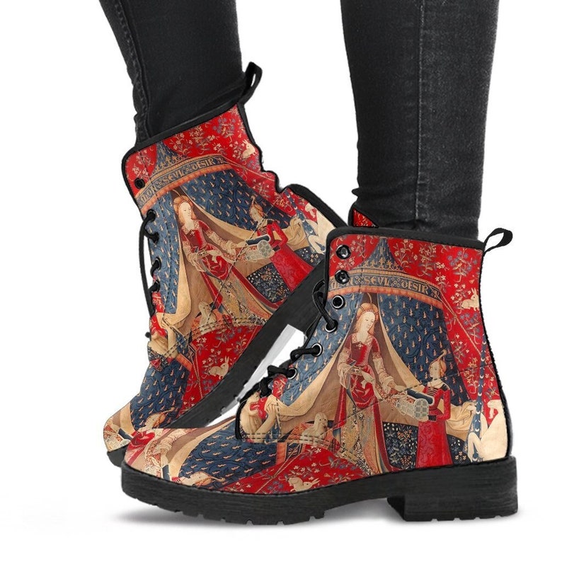 the lady and the unicorn lace up combat style boots.  Just above ankle length boots in red and blue colours.  A vibrant print of the lady and the unicorn tapestry.  the boots have a black rubber sole.