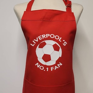 Fan Liverpoolu nr 1 - możliwość personalizacji. Średniej wielkości fartuch dla dorosłych z kieszenią. Wyprodukowano w Anglii