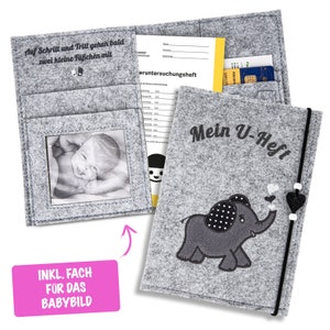 Könnte beinhalten: Grauer Filz-Babybuchumschlag mit einem gestickten Elefantenmotiv. Der Umschlag hat eine Tasche für ein Foto und einen Schlitz für eine Karte. Der Text "Mein U-Heft" ist auf den Umschlag gestickt.