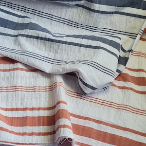 Yarn-dyed horizontal stripe seersucker cotton fabric. Blue/rust by the half metre