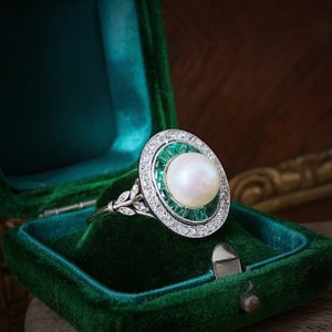 An Art Deco Natural Pearl, Emerald And Diamond Platinum Ring, Circa 1925