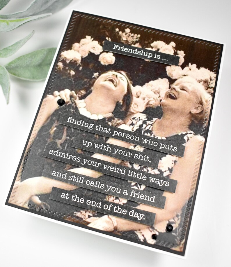May include: A black and white photo of two women laughing. The photo is framed with a black border and has a quote about friendship written on it. The quote reads: "Friendship is... finding that person who puts up with your shit, admires your weird little ways and still calls you a friend at the end of the day."