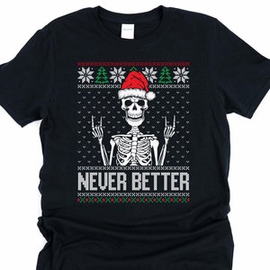 May include: Black t-shirt with a skeleton wearing a Santa hat and giving the rock and roll hand gesture. The text "NEVER BETTER" is below the skeleton. The top of the shirt has a Christmas sweater design with snowflakes and trees.