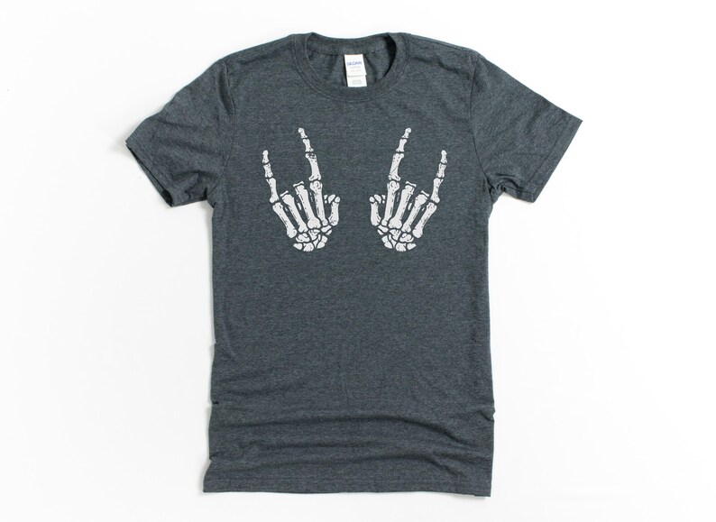 May include: A dark heather gray t-shirt with a white skeleton hand graphic making the rock and roll hand gesture.