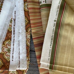 May include: Selection of fabric swatches in diverse patterns and colours. Features a white fabric strip with text from "The Robert Allen Group, Inc." and a striped fabric with "WAVERLY SCREEN PRINT" text.
