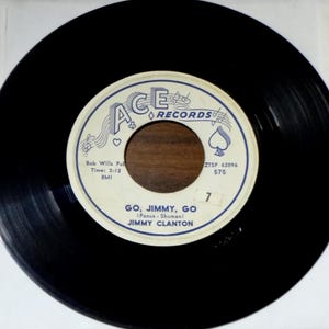 May include: A black vinyl record with a white and blue label featuring the text "GO, JIMMY, GO" by Jimmy Clanton. The label also includes the Ace Records logo and other text. The record is a vintage music item.