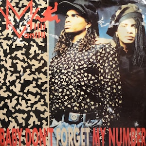May include: A black and white record cover with a red and white logo for the group "Millie Vanilli". The cover features a photo of two men wearing hats and patterned shirts. The text "Baby Don't Forget My Number" is printed in red at the bottom of the cover.