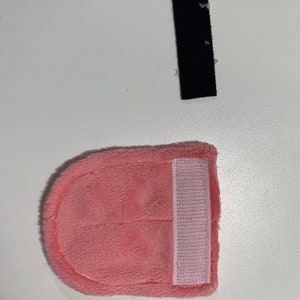 Op de afbeelding: Een roze pluche stoffen hoofdband met een roze klittenbandsluiting.