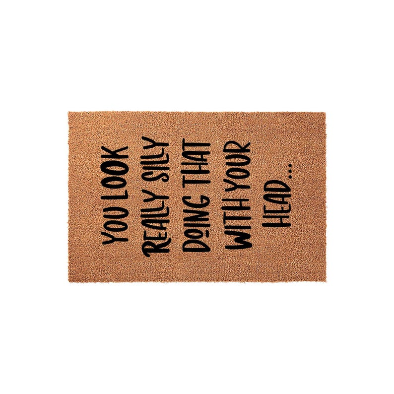 A textured area rug with a humorous message printed on it.