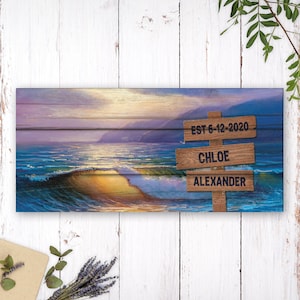 May include: A wooden sign with a beach scene background. The sign has three lines of text: "EST 6-12-2020", "CHLOE", and "ALEXANDER".