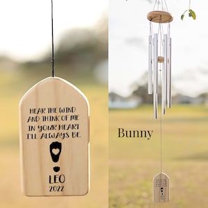 a wind chime hanging from a tree in a field