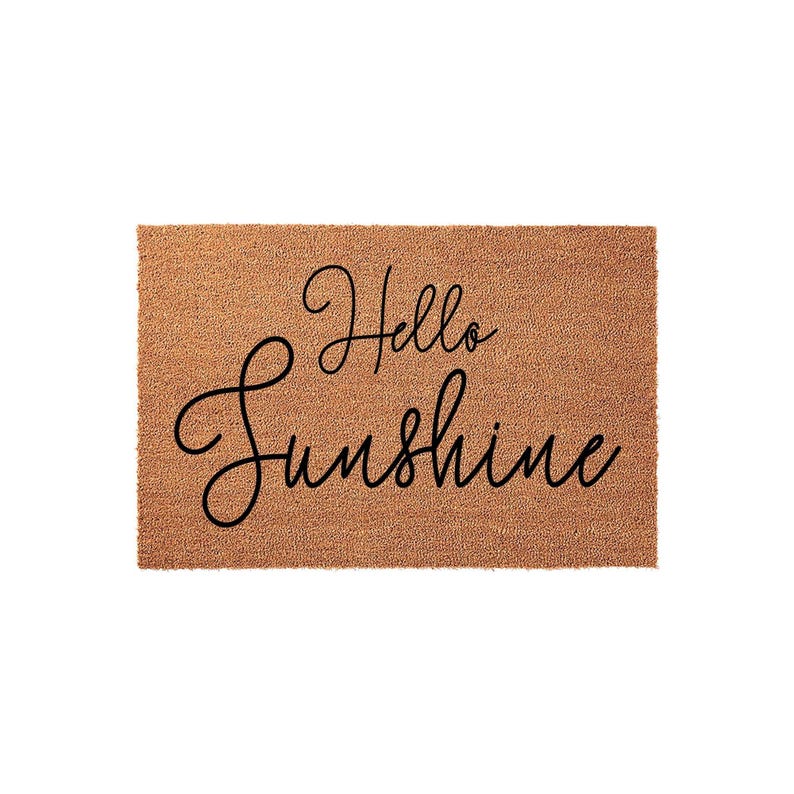 A textured doormat with the phrase "Hello Sunshine" written on it in a cursive font.