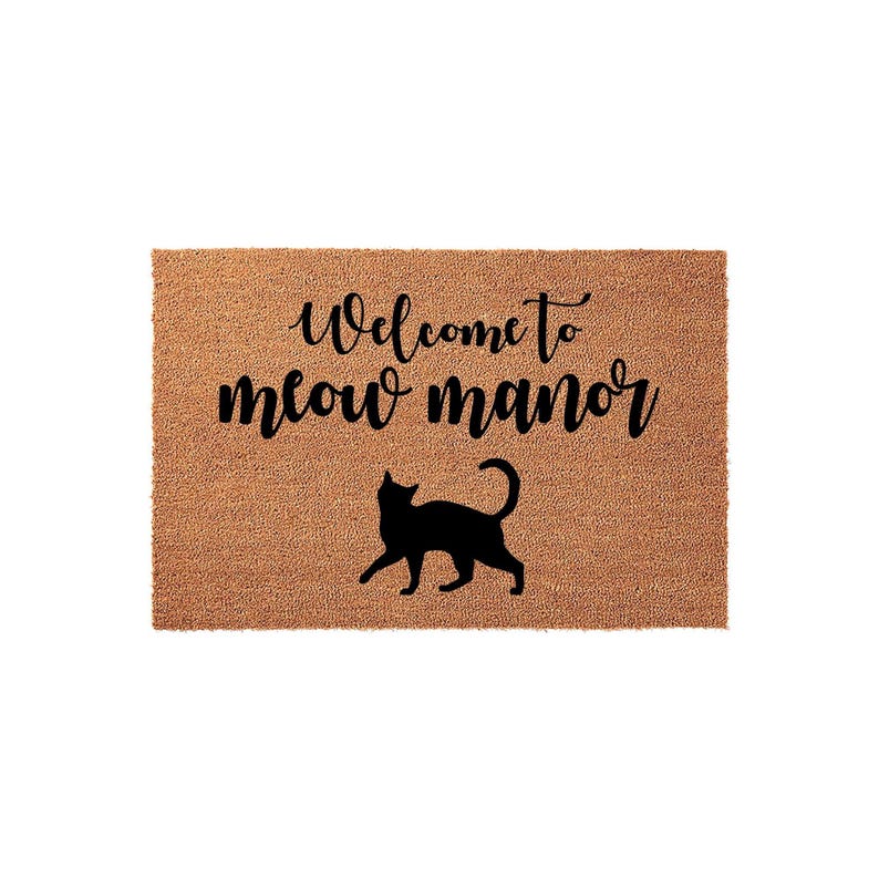 A textured doormat with the phrase "Welcome to meow manor" printed on it, along with a silhouette of a cat.