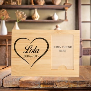May include: A wooden photo frame with a heart and the text "Lola 2004-2019" engraved on the left side. The right side has a cutout for a photo with the text "Furry Friend Here".