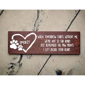 May include: A brown wooden sign with white text and paw prints. The text reads "SMOKEY WHEN TOMORROW STARTS WITHOUT ME, WE'RE NOT SO FAR APART. JUST REMEMBER THE PAW PRINTS I LEFT INSIDE YOUR HEART."