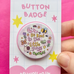 Peut inclure: Un badge rond sur une carte de présentation blanche à motif quadrillé. Le badge présente un fond à carreaux violet clair et blanc avec des illustrations de ver, d'abeille, de papillon, d'escargot et de chenille, et le texte Be kind to the little guys.