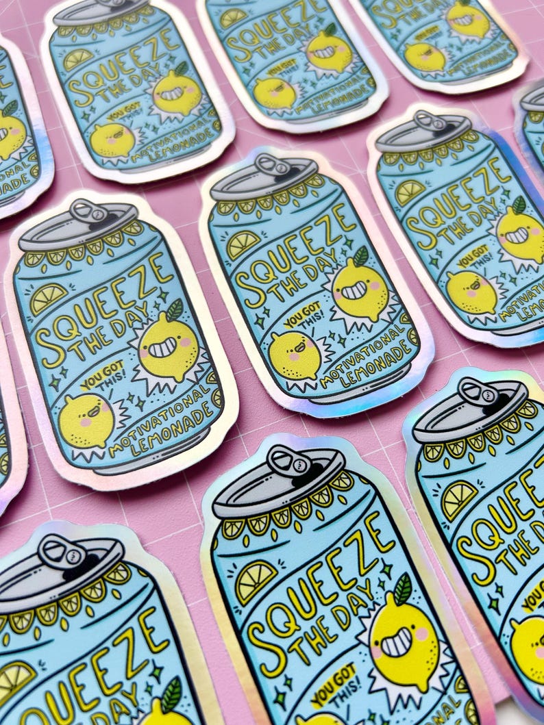 May include: A set of holographic stickers featuring a blue can with a yellow lemon and the text "Squeeze the Day! You got this! Motivational Lemonade".