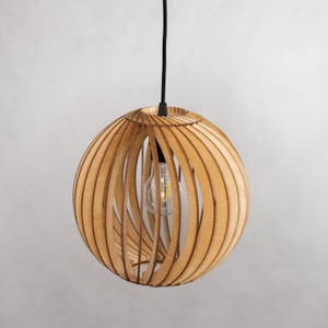 May include: A wooden pendant light fixture with a spherical shade made of thin, slatted wood. The shade has a natural wood finish and is suspended from a black cord.