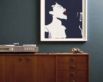 Op de afbeelding: Een ingelijste poster met een donkerblauwe achtergrond waarop een wit silhouet van Billie Holiday te zien is die in een microfoon zingt. De tekst "Billie Holiday" is in roze letters bovenaan de poster gedrukt.