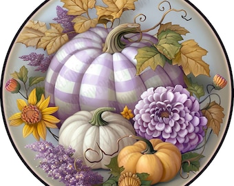 May include: A circular decorative plate featuring a large lavender and white gingham pumpkin, a smaller white pumpkin, and a small orange pumpkin. The arrangement is accented with yellow sunflowers, purple flowers, and brown autumn leaves.
