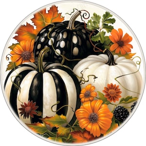 May include: A circular decorative print featuring three pumpkins: one black with white polka dots, one with black and white vertical stripes, and one solid white. The arrangement is accented with orange flowers, green leaves, and blackberries.
