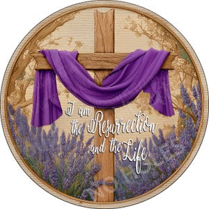 May include: Circular artwork featuring a wooden cross draped with a purple cloth. The cross is set against a backdrop of lavender and trees. The text "I am the Resurrection and the Life" is displayed in white script.