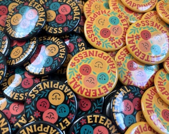 May include: A collection of round buttons with the words "ETERNAL HAPPINESS" encircling a design of smiling faces and floral accents. The buttons are in shades of black, yellow, red, teal, and orange.