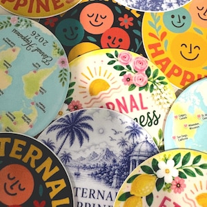 May include: A collection of circular stickers featuring various designs including smiling faces, world maps with location markers, tropical landscapes in blue and white, and floral motifs with lemons, all labeled with the text Eternal Happiness 2026.