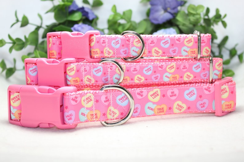 Puede incluir: Cuatro collares para perros de color rosa con anillas en D plateadas y hebillas de pl&aacute;stico rosa. Los collares est&aacute;n decorados con un patr&oacute;n rosa y blanco de corazones de caramelo con varios mensajes, entre ellos "Sweet Love", "True Love", "Hug Me" y "Be Mine".