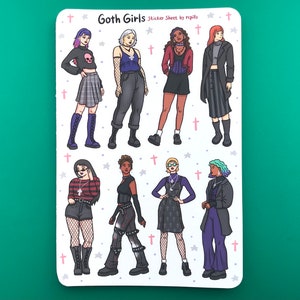Pu&ograve; includere: Un foglio di adesivi con illustrazioni di otto ragazze goth in diversi abiti. Il foglio di adesivi &egrave; bianco con croci e stelle rosa. Il testo "Goth Girls Sticker Sheet by repills" &egrave; in cima al foglio.