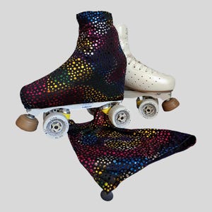 Può includere: Un paio di pattini a rotelle, uno coperto da un tessuto nero con un motivo a pois iridescenti multicolori e uno color bianco sporco. La copertura in tessuto nero si estende anche verso il basso, mostrando lo stesso vivace motivo a pois.