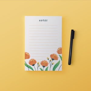May include: A white lined notepad with the word "notes" printed at the top. The notepad has a floral border with orange flowers and green leaves.