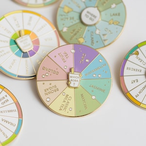 May include: A gold-coloured spinning wheel with a variety of boba tea flavours printed on it. The wheel has a small, gold-coloured boba cup in the centre with the words "Which Boba?" printed on it.