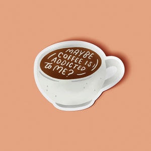May include: A white coffee cup sticker with a brown coffee fill. The text "MAYBE COFFEE IS ADDICTED TO ME?" is written in white. The sticker is on a peach-colored background.