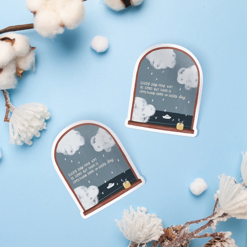 May include: Two gray and brown framed chalkboard stickers with a white cloudy sky and raindrops. The text on the stickers reads "Every day may not be good but there is something good in every day."