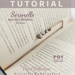 Könnte beinhalten: Ein handgefertigter Lesezeichen aus Kupferdraht mit Perlen- und Perlendetails, das auf einem offenen Buch liegt. Das Lesezeichen ist Teil der "Pearl Collection" und ist ein Tutorial. Der Text "Serenelle Wire Wrap Bookmark Tutorial" ist sichtbar.