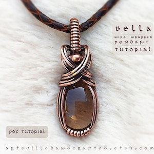 K&ouml;nnte beinhalten: Ein mit Kupferdraht umwickelter Anh&auml;nger mit einem braunen Edelstein. Der Anh&auml;nger h&auml;ngt an einer braunen Lederschnur. Der Text "bella wire wrapped pendant tutorial" ist auf wei&szlig;em Hintergrund geschrieben. Der Text "pdf tutorial" ist unter dem Anh&auml;nger geschrieben. Der Text "artsvillehandcraftedsets.com" ist unter dem Text "pdf tutorial" geschrieben.
