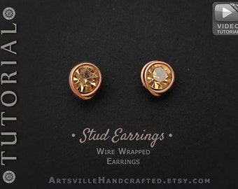 May include: A pair of gold wire wrapped stud earrings with a small, round, amber-colored gemstone in the center of each earring.