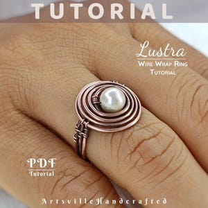 May include: A copper wire wrap ring with a pearl centre is displayed on a finger. The ring has a spiral design and is part of a tutorial. The word "Tutorial" is at the top of the image, and "Lustra Wire Wrap Ring Tutorial" is written in the image.
