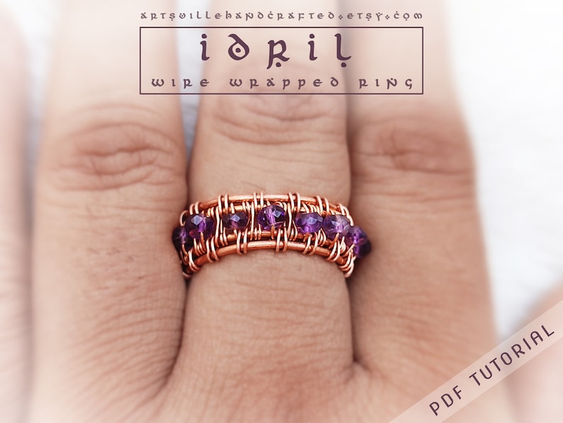 May include: A copper wire wrapped ring with a row of purple beads. The ring is on a finger.